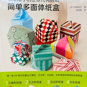 Puede incluir: Una portada de libro con el título "Cajas de papel multifacéticas simples" en japonés e inglés. La portada presenta cajas de origami de colores en varias formas, incluyendo triangulares, cuadradas, pentagonales y rectangulares.