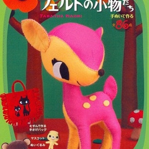 May include: A book cover with a pink and yellow felt deer on the front. The book title is "Kawaii Felt Animals" and the text "Handmade" is also on the cover. The book is in Japanese.