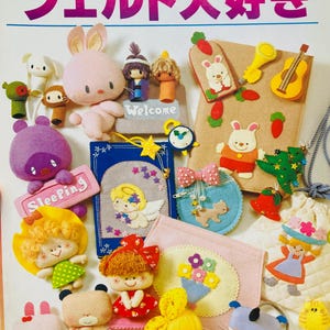 May include: A colorful book cover with Japanese text and felt craft projects. The cover features felt creations of animals, dolls, and accessories. The projects include a bunny, angel, and a radio. The book is titled "Ondori".
