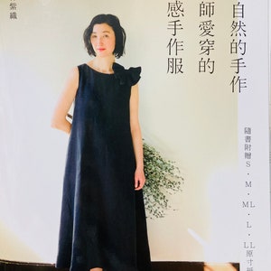以下が含まれることがあります： 黒いノースリーブのドレスを着た女性。肩にフリルが付いています。画像は、日本語のテキストを含む本からのもので、「快適な自然な手作り」と「デザイナーのお気に入りの手作り服」が含まれています。