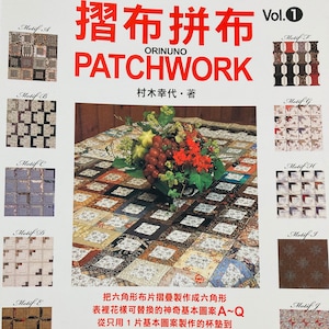 Peut inclure: Une couverture de livre avec le titre "Patchwork de tissu pliable Vol. 1" en japonais. La couverture présente une courtepointe en patchwork colorée avec un arrangement floral au centre. Le livre est de Yukiko Muraki.