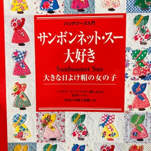 May include: A book cover with a patchwork design of Sunbonnet Sue figures in different fabrics and colours. The cover has Japanese text and the title "Sunbonnet Sue".