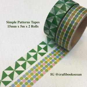 May include: Two rolls of decorative tape with geometric patterns. One roll features a green and white triangle design, and the other has a green, blue, yellow, and pink square pattern. The text on the image reads "Simple Patterns Tapes 15mm x 5m x 2 Rolls".