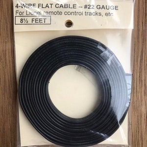 May include: A black 4-wire flat cable for Lionel remote control tracks, etc. The cable is coiled and measures 8 1/2 feet in length. The cable is packaged in a clear plastic bag with a white label.
