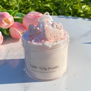 May include: A pink Hello Kitty themed slime in a clear jar with a Hello Kitty marshmallow topper, white pearl beads, and pink and white sprinkles. The jar has a label that reads "Hello Kitty Frappé Sweet and dreamy just like Kitty!"