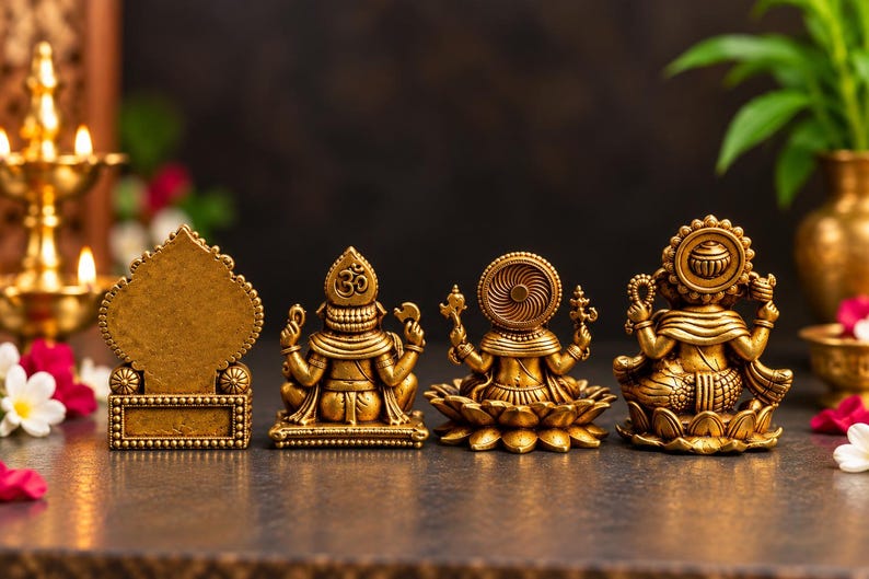 May include: Four gold-colored statues arranged in a row. The first is a rectangular plaque with a pointed top. The second is a deity figure with an Om symbol. The third is a deity on a lotus base. The fourth is a deity with a circular halo.