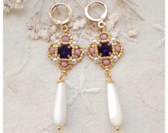 May include: Gold earrings with a square design featuring pink and white beads, a purple gemstone, and a white pearl drop.