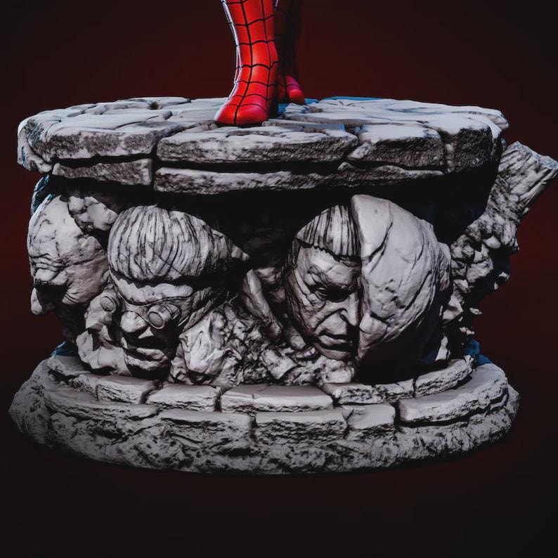May include: A detailed statue base featuring sculpted villain faces in shades of gray. The base supports a figure with red boots. The base has a textured, stone-like appearance, with a dark red background.