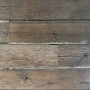 May include: Close-up of a wall made of reclaimed wood planks. The wood is a light brown color with a weathered, distressed look. The planks are arranged horizontally and have a natural grain pattern.