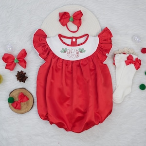 Puede incluir: Conjunto de bebé de satén rojo con cuello blanco con diseño bordado. El conjunto incluye diadema, calcetines y lazos a juego. Ropa de bebé con temática navideña.