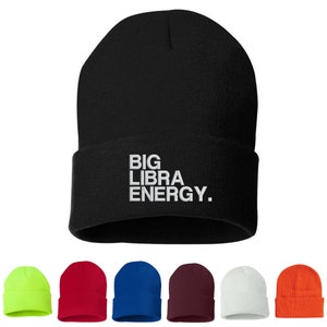 May include: A black beanie with the text "BIG LIBRA ENERGY." in white lettering. The beanie is shown in 10 different colors: neon green, red, blue, maroon, white, orange, black, pink, grey, and brown.