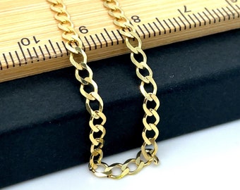 May include: A gold curb chain necklace, laid out on a black surface and a wooden ruler. The chain is approximately 19 inches long.