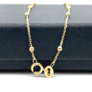 May include: A gold chain bracelet with small round beads. The bracelet has a lobster clasp.