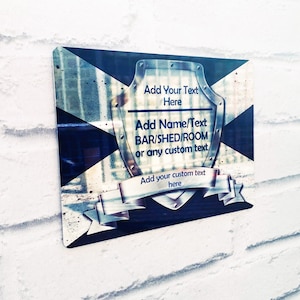 Puede incluir: Un escudo negro y blanco con un borde dorado y una cinta. El escudo tiene texto que dice "Add Your Text Here", "Add Name/Text BAR/SHED/ROOM or any custom text", y "Add your custom text here".