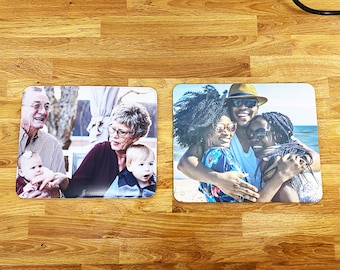 Op de afbeelding: Twee gepersonaliseerde foto-muismatten. De eerste muismat heeft een foto van een gezin van drie, waaronder een grootvader, grootmoeder en een klein kind. De tweede muismat heeft een foto van een groep van vier vrienden die elkaar omhelzen op een strand.