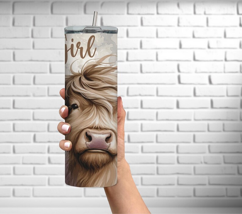 K&ouml;nnte beinhalten: Ein Edelstahlbecher mit einer Illustration einer braunen und wei&szlig;en Highland-Kuh und dem Text "A girl" auf der Seite.