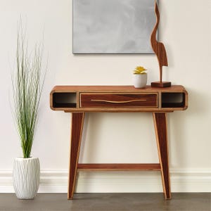 May include: A wooden console table with a drawer and a lower shelf. The table has a unique, curved design and is made of different types of wood.
