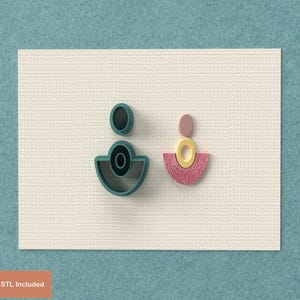 May include: Two abstract earring-shaped cookie cutters. One is teal and black, the other is pink, yellow, and pink. The cookie cutters are on a textured white surface with a teal background. The text "Digital STL Included" is visible.