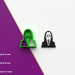 Puede incluir: Dos cortadores de galletas impresos en 3D con forma de la máscara de Ghostface de la franquicia de películas Scream. El cortador de la izquierda es verde y el de la derecha es negro.