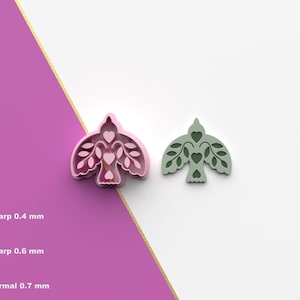 May include: Two bird-shaped cookie cutters. One is pink, the other is green. Both have heart and leaf details. The pink cutter is next to a purple and white background. The green cutter is on a white background. The image also includes text and an STL icon.