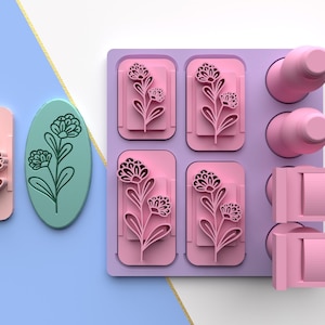 May include: A set of six pink silicone molds with floral designs. The molds are arranged in a rectangular tray with a purple background. There are also two pink silicone molds with a rectangular shape.