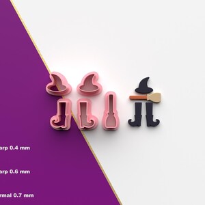 Puede incluir: Cortadores de galletas rosas y negros con temática de Halloween con forma de sombrero de bruja, botas y escoba. La imagen también incluye un sombrero y una escoba de bruja, y un par de botas. Fondo blanco y morado.