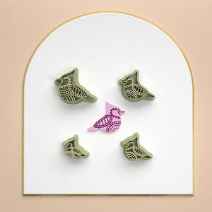 Puede incluir: Cinco cortadores de galletas con forma de pájaros. Cuatro son verdes con diseños intrincados y uno es rosa con un diseño simple.