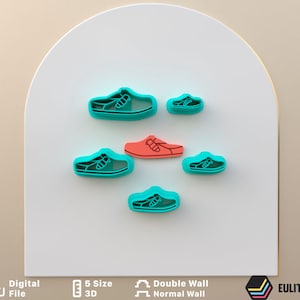 Op de afbeelding: Set van zes koekjesvormen in de vorm van schoenen. De vormen zijn turquoise blauw en rood. De vormen zijn in een halve cirkel op een wit oppervlak gerangschikt.  De vormen zijn verkrijgbaar in vijf maten.  De vormen zijn dubbelwandig.