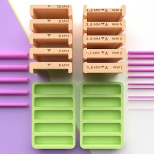 Puede incluir: Vista cenital de accesorios de impresión 3D. Hay varias piezas rectangulares beige etiquetadas con medidas de 0,5 mm a 10 mm. También se incluyen varillas cilíndricas rosas y dos bandejas rectangulares verdes. El icono del archivo STL está en la esquina superior derecha.