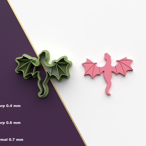May include: Two 3D printed dragon cookie cutters, one green and one pink. The cutters are designed to create detailed dragon shapes for cookies or fondant.