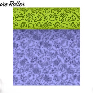 May include: A 3D printed texture roller with a purple and green design. The roller features a repeating pattern of various magical symbols, including a cauldron, a wand, a crystal, a crescent moon, and a potion bottle. The text "Texture Roller" is printed at the top of the image.