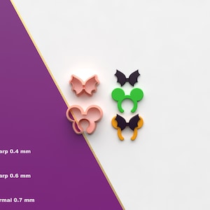 May include: A collection of colorful cookie cutters in the shapes of a bow, Mickey Mouse ears, a bat, and a Halloween headband. The cutters are pink, green, black, and yellow. The image also shows the STL file icon.