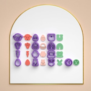 May include: A set of 20 purple, green, and pink plastic cookie cutters featuring Easter-themed designs, including bunnies, eggs, carrots, and shamrocks.