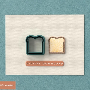 May include: A teal-colored bread-shaped cookie cutter next to a slice of toast. The toast has a light brown crust and a yellow center. A small, orange rectangle with the words "DIGITAL DOWNLOAD" is below the bread shapes.