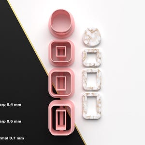 Puede incluir: Colección de cortadores de arcilla polimérica rosa y blanco con diseño de mármol para manualidades. Los cortadores tienen varias formas, incluyendo cuadrados y rectángulos. La imagen también muestra el filo de corte: 0,4 mm, 0,6 mm y 0,7 mm.