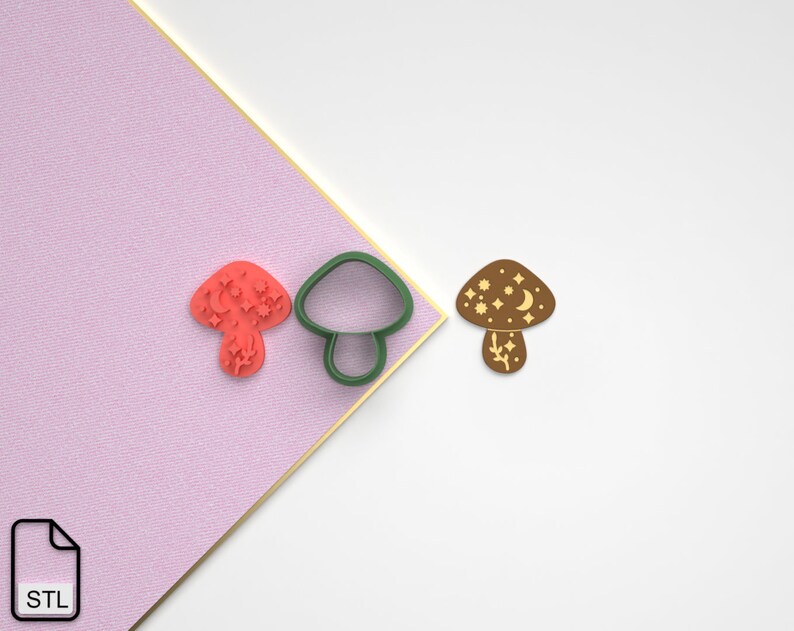 Pode incluir: Um conjunto de tr&ecirc;s cortadores de biscoitos de cogumelo impressos em 3D. Os cortadores t&ecirc;m a forma de um cogumelo com uma lua crescente e estrelas no chap&eacute;u. Os cortadores s&atilde;o verdes, marrons e vermelhos.