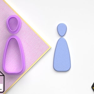 May include: A purple plastic cookie cutter in the shape of a person. The cookie cutter is on a pink and white patterned surface. An STL file icon is in the lower left corner of the image.