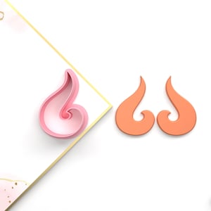 May include: Two 3D printed cookie cutters in the shape of a stylised flame. One cutter is pink and the other is orange.
