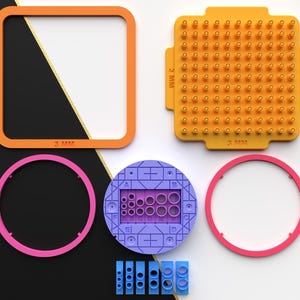 May include: A set of 3D printed molds for resin casting. The molds are orange, pink, and purple. The molds are in the shape of circles and squares. The molds are 3 mm thick. The molds are labeled with the text "3 MM".