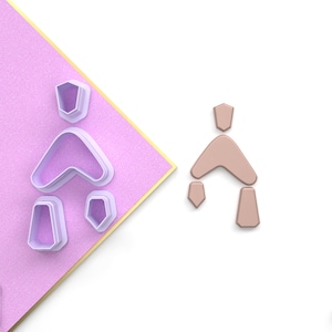 Puede incluir: Un archivo STL impreso en 3D para un cortador de galletas con forma de persona. El cortador se muestra en plástico morado y una versión impresa en 3D rosa se muestra al lado.