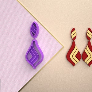 May include: A pair of earrings with a teardrop shape. The earrings are red with yellow stripes. The earrings are shown next to a purple teardrop-shaped earring.
