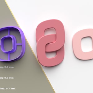 May include: Three letter O shapes in different colors. A purple plastic letter O cookie cutter with a square inside. Two pink letter O shapes, one interlocked with another. A light pink letter O.