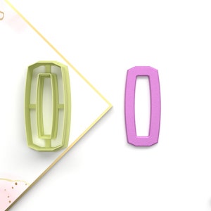 Puede incluir: Dos cortadores de galletas, uno en verde claro y otro en rosa, con forma de número cero. Los cortadores están diseñados con un doble contorno para un efecto decorativo.