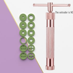 Puede incluir: Una extrusora de metal color rosa dorado con un mango y un juego de 10 boquillas de plástico verde. La extrusora NO está en el archivo.