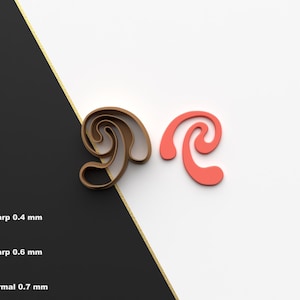 May include: Two cookie cutters, one brown and one red, shaped like a stylized letter "R".