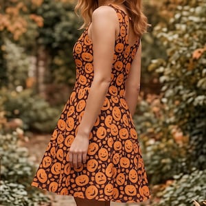 May include: A sleeveless skater dress featuring a repeating pattern of orange jack-o'-lanterns on a dark brown background. The dress has a fitted bodice and a flared skirt that falls above the knee, paired with brown leather ankle boots.