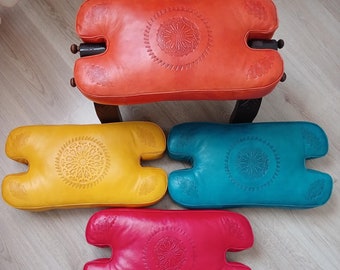 アンティークのラクダの鞍、素朴な木製の足置き、古びた素朴な布張りの