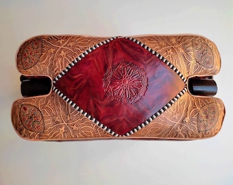 アンティークのラクダの鞍、素朴な木製の足置き、古びた素朴な布張りの