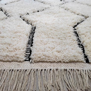 May include: White shag rug with black geometric designs and a fringe border.