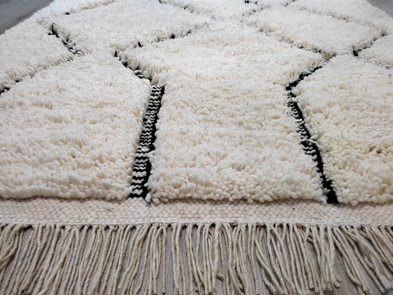 May include: White shag rug with black geometric designs and a fringe border.